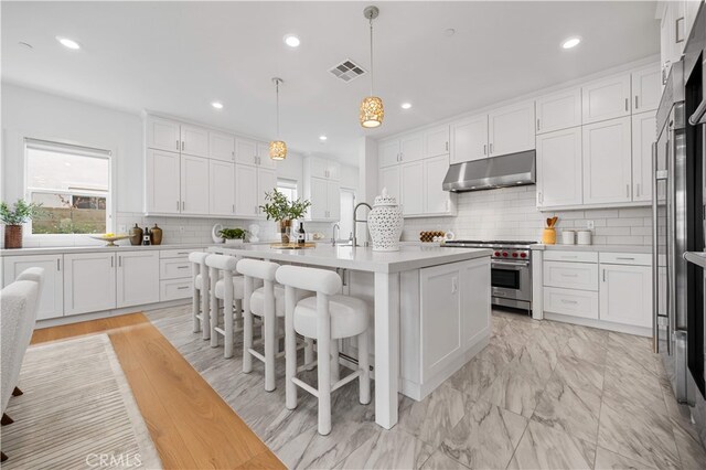 72 Crater, Irvine, CA 92618 - kitchen with high end appliances, under cabinet range hood, light countertops, white cabinets, and recessed lighting