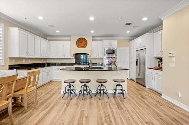 2185 Twain Ave, Carlsbad, CA 92008 - kitchen with appliances with stainless steel finishes, a breakfast bar, crown molding, white cabinets, and a center island with sink