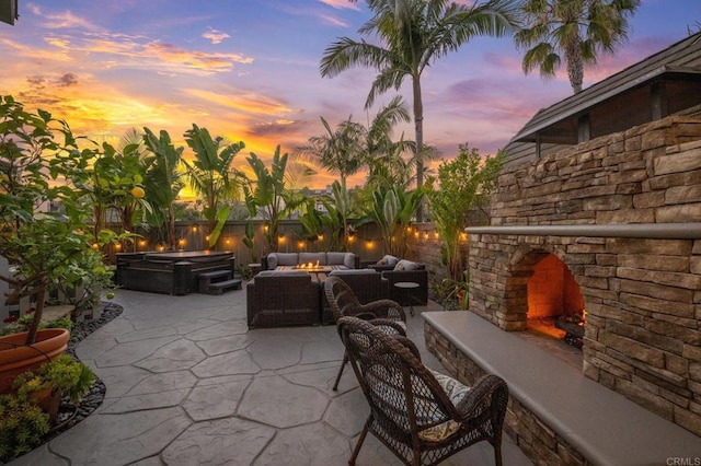 2185 Twain Ave, Carlsbad, CA 92008 - patio terrace at dusk with an outdoor living space with a fireplace, a patio, a hot tub, and a fenced backyard