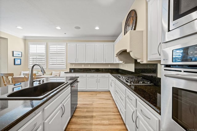 2185 Twain Ave, Carlsbad, CA 92008 - kitchen featuring a sink, appliances with stainless steel finishes, crown molding, white cabinets, and light wood-style flooring