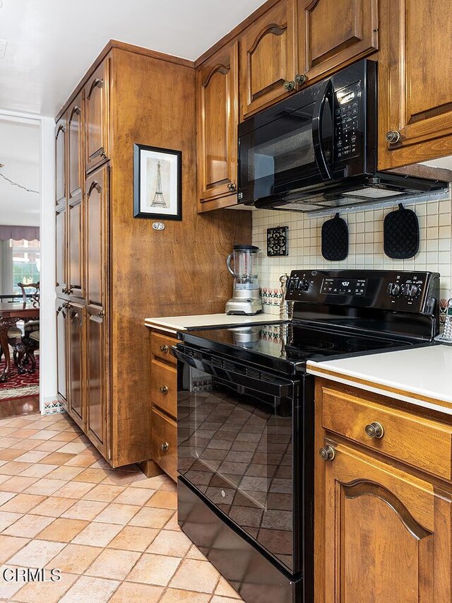 848 S Orange Grove Blvd, Pasadena, CA 91105 - kitchen with black appliances, decorative backsplash, brown cabinetry, and light countertops
