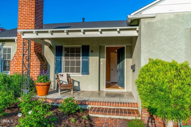 1736 Craig Ave, Altadena, CA 91001 - property entrance featuring covered porch, a chimney, stucco siding, and roof with shingles