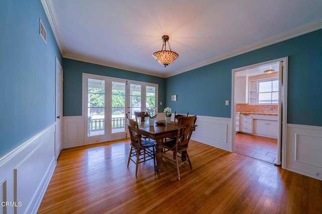 1736 Craig Ave, Altadena, CA 91001 - dining area with healthy amount of natural light, wainscoting, wood finished floors, a decorative wall, and ornamental molding