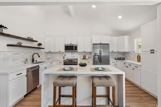 1208 Via Viento Suave, San Marcos, CA 92078 - kitchen featuring stainless steel appliances, a sink, a breakfast bar, a center island, and beamed ceiling