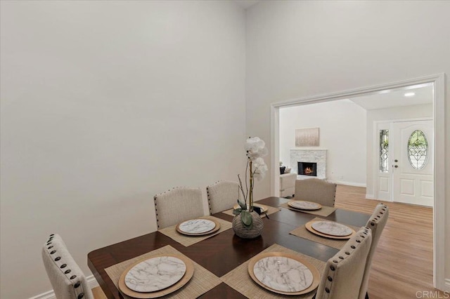 1208 Via Viento Suave, San Marcos, CA 92078 - dining area featuring light wood-style flooring, a fireplace, and baseboards