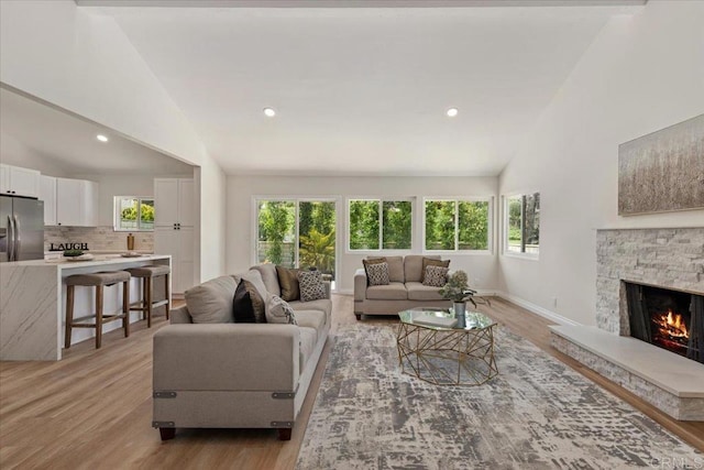 1208 Via Viento Suave, San Marcos, CA 92078 - living area with healthy amount of natural light, light wood-type flooring, a stone fireplace, baseboards, and recessed lighting
