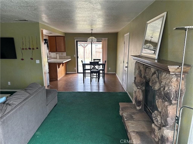 37824 Queensboro Ct, Palmdale, CA 93552 - living area with dark colored carpet, a textured ceiling, a stone fireplace, baseboards, and a chandelier