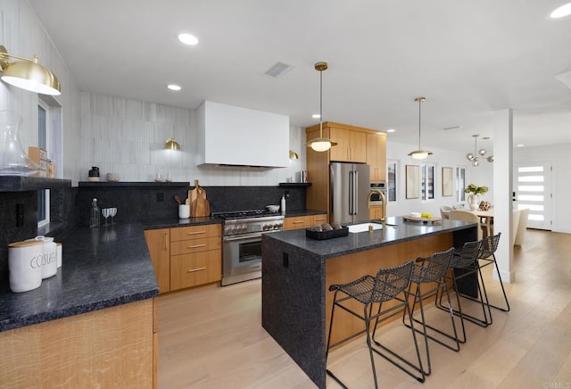 3852 Bledsoe Ave, Los Angeles, CA 90066 - kitchen featuring stainless steel appliances, a kitchen bar, a sink, tasteful backsplash, and light wood finished floors