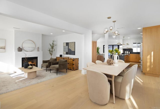 3852 Bledsoe Ave, Los Angeles, CA 90066 - dining space featuring light wood-type flooring, a warm lit fireplace, recessed lighting, and a chandelier