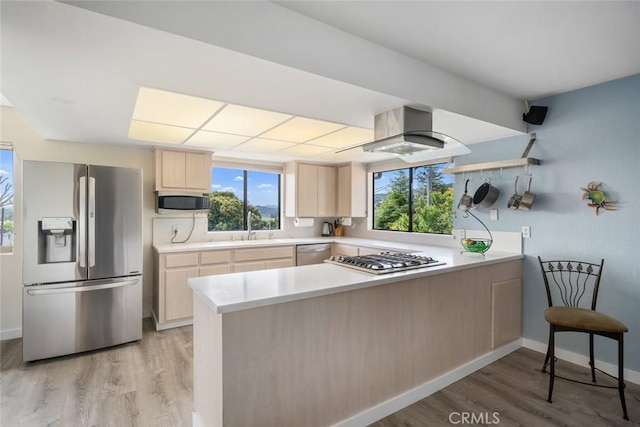 6058 Joan Pl, San Luis Obispo, CA 93401 - kitchen with stainless steel appliances, light brown cabinetry, a peninsula, light countertops, and light wood-style flooring