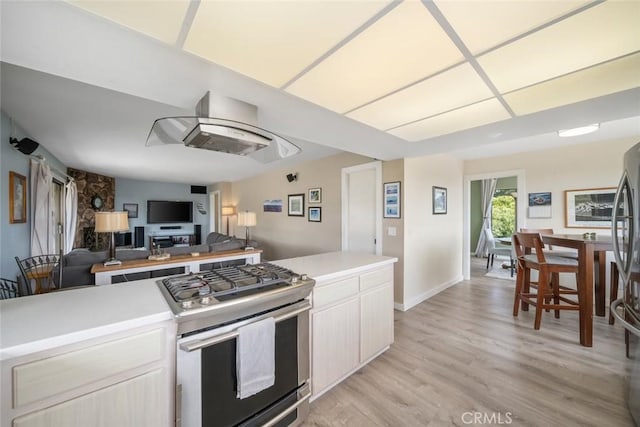 6058 Joan Pl, San Luis Obispo, CA 93401 - kitchen with stainless steel appliances, light countertops, island range hood, light wood finished floors, and white cabinets