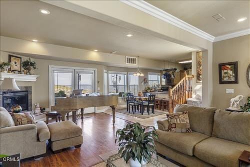 26941 Stirrup Way, Tehachapi, CA 93561 - living room featuring crown molding, stairs, a glass covered fireplace, wood finished floors, and recessed lighting
