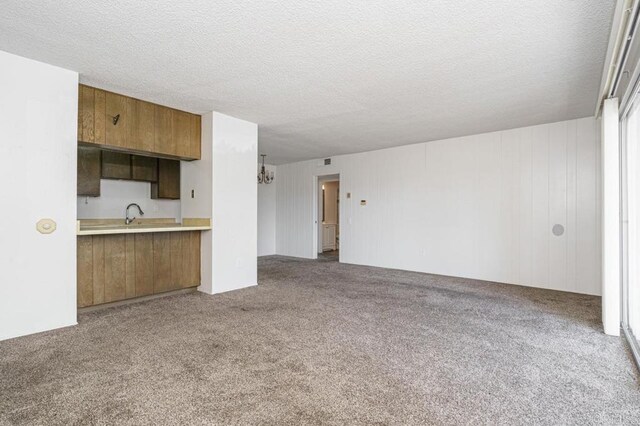 5700 Baltimore Dr Unit 134, La Mesa, CA 91942 - unfurnished living room with carpet flooring, a textured ceiling, and a chandelier