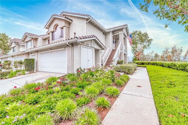21011 Marin Unit 103, Lake Forest, CA 92630 - view of front of house with a garage, stucco siding, driveway, stairway, and a tiled roof