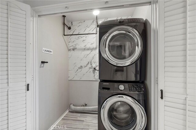 21011 Marin Unit 103, Lake Forest, CA 92630 - laundry area featuring stacked washer / drying machine and wood finished floors