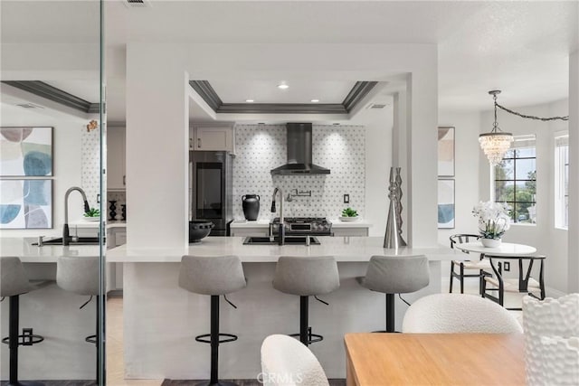 21011 Marin Unit 103, Lake Forest, CA 92630 - kitchen with wall chimney range hood, fridge, light countertops, a raised ceiling, and decorative backsplash