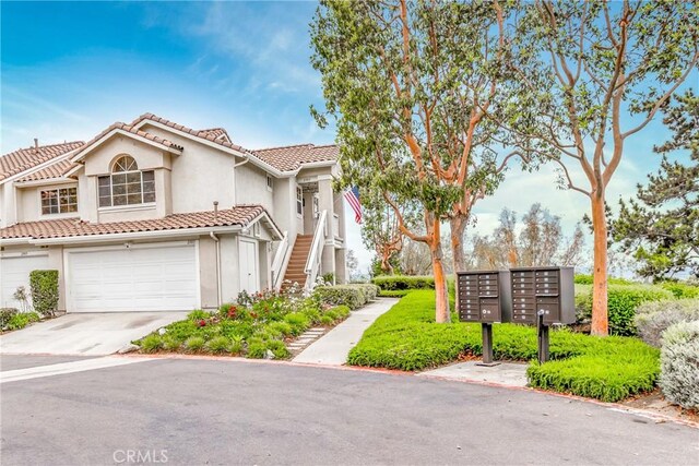 21011 Marin Unit 103, Lake Forest, CA 92630 - view of front of house featuring a tiled roof, stucco siding, concrete driveway, a garage, and stairs