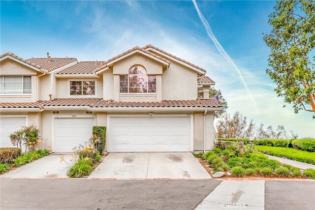 21011 Marin Unit 103, Lake Forest, CA 92630 - view of front of house with stucco siding, concrete driveway, an attached garage, and a tile roof