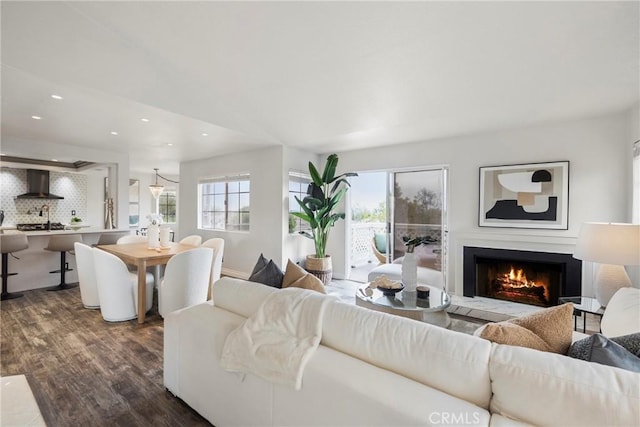 21011 Marin Unit 103, Lake Forest, CA 92630 - living room featuring dark wood-style flooring, healthy amount of natural light, a warm lit fireplace, and recessed lighting