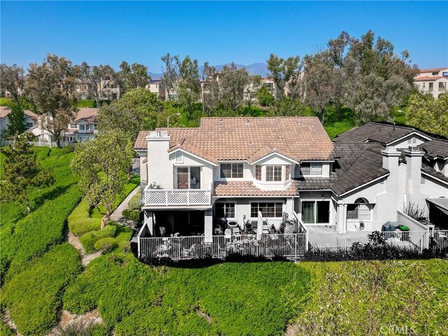 21011 Marin Unit 103, Lake Forest, CA 92630 - back of property with a tile roof, a fenced backyard, a balcony, a patio area, and stucco siding