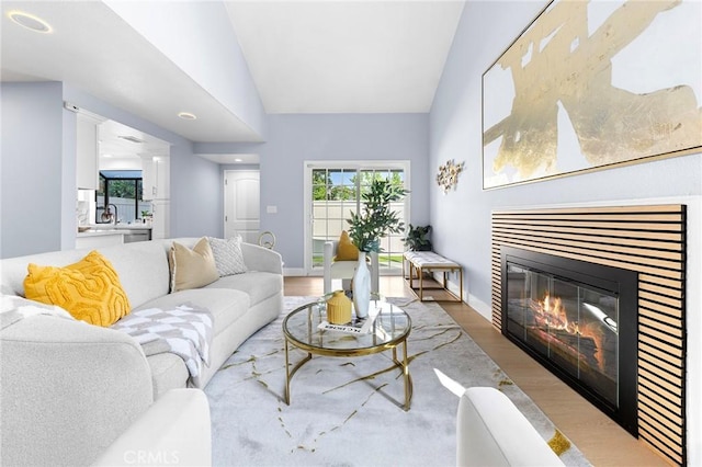 11636 Lambert Ave Unit 12, El Monte, CA 91732 - living area featuring wood finished floors, vaulted ceiling, and a glass covered fireplace