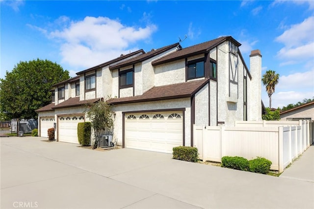 11636 Lambert Ave Unit 12, El Monte, CA 91732 - view of front of property featuring driveway, a garage, stucco siding, and a chimney