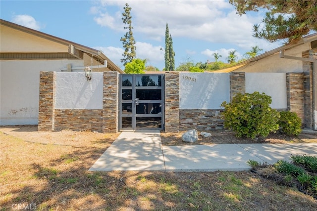 19941 Hiawatha St, Chatsworth, CA 91311 - doorway to property with a gate, stucco siding, and stone siding