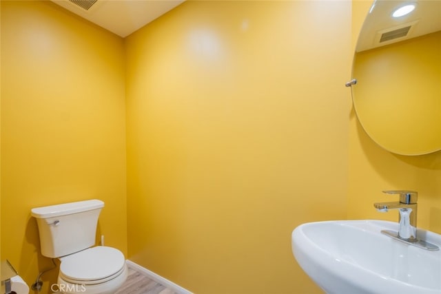 19941 Hiawatha St, Chatsworth, CA 91311 - half bathroom featuring a sink, toilet, wood finished floors, and baseboards