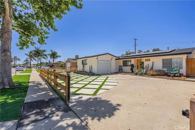 9551 Barkerville Ave, Whittier, CA 90605 - ranch-style home featuring an attached garage, concrete driveway, roof mounted solar panels, and stucco siding