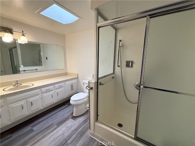 13540 Saint Andrews Dr Unit M14-4J, Seal Beach, CA 90740 - full bathroom with a skylight, a shower with shower door, vanity, toilet, and wood finished floors