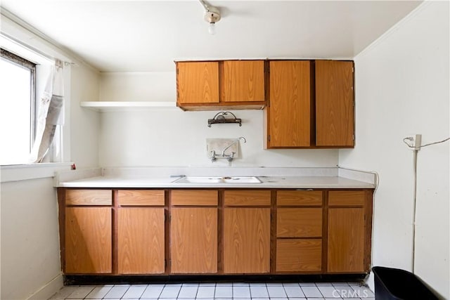 3339 E 4th St, Los Angeles, CA 90063 - kitchen with open shelves, light countertops, brown cabinetry, and light tile patterned flooring