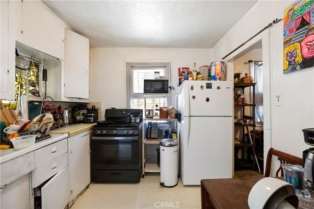 3339 E 4th St, Los Angeles, CA 90063 - kitchen with black appliances, tile counters, and white cabinets