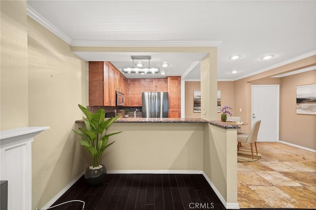 950 N Kings Rd Unit 160, West Hollywood, CA 90069 - kitchen with appliances with stainless steel finishes, brown cabinetry, recessed lighting, ornamental molding, and a peninsula
