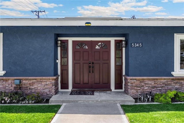 5345 Kenwood Ave, Buena Park, CA 90621 - doorway to property featuring stone siding, stucco siding, and a lawn