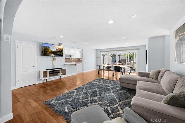 5345 Kenwood Ave, Buena Park, CA 90621 - living room featuring wood finished floors, baseboards, recessed lighting, and arched walkways