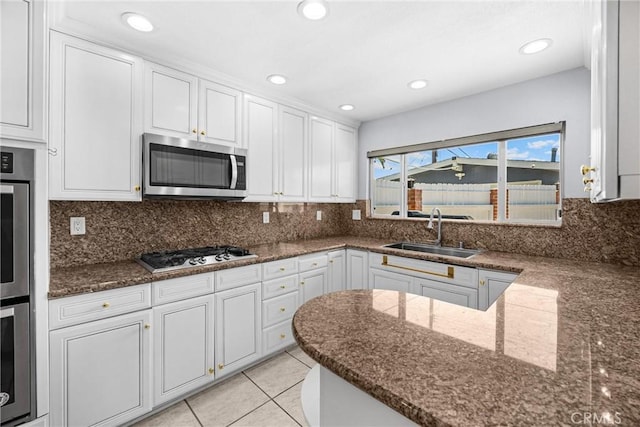 5345 Kenwood Ave, Buena Park, CA 90621 - kitchen with appliances with stainless steel finishes, a sink, white cabinetry, dark stone counters, and recessed lighting