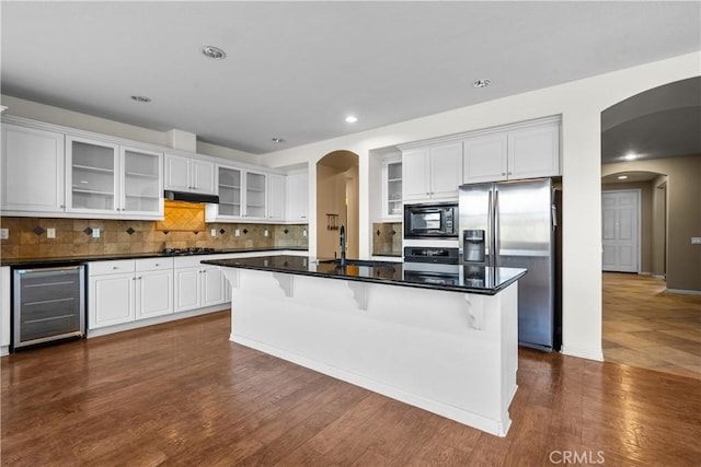 2123 Coconut Pl, Palmdale, CA 93551 - kitchen featuring beverage cooler, black appliances, arched walkways, white cabinets, and recessed lighting
