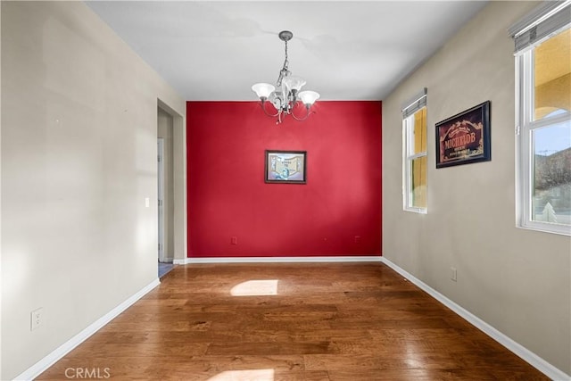 2123 Coconut Pl, Palmdale, CA 93551 - unfurnished dining area featuring a chandelier, an accent wall, and wood finished floors