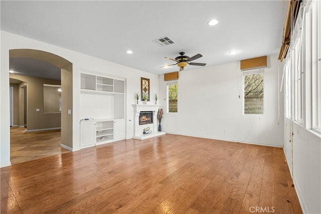 2123 Coconut Pl, Palmdale, CA 93551 - unfurnished living room with ceiling fan, built in shelves, light wood finished floors, a glass covered fireplace, and recessed lighting