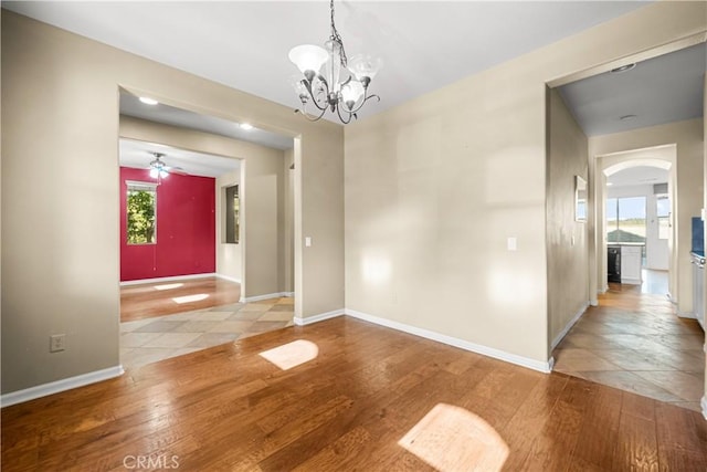 2123 Coconut Pl, Palmdale, CA 93551 - unfurnished dining area with arched walkways, wood finished floors, a chandelier, and a ceiling fan