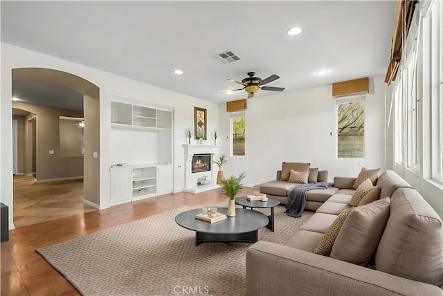 2123 Coconut Pl, Palmdale, CA 93551 - living area featuring a ceiling fan, arched walkways, built in features, a glass covered fireplace, and recessed lighting