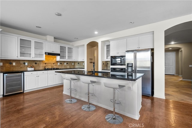 2123 Coconut Pl, Palmdale, CA 93551 - kitchen featuring beverage cooler, arched walkways, stainless steel appliances, a kitchen breakfast bar, and recessed lighting