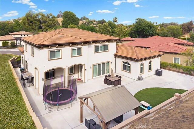 1279 Waterbrook Cir, Walnut, CA 91789 - back of house with a patio, a trampoline, stucco siding, and a tile roof