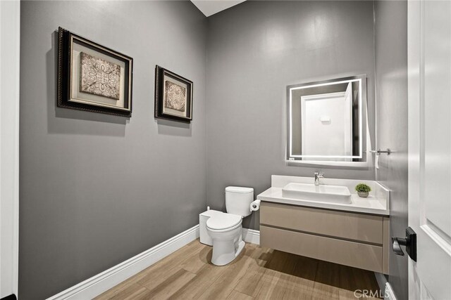 1279 Waterbrook Cir, Walnut, CA 91789 - half bathroom with toilet, wood finished floors, vanity, and baseboards