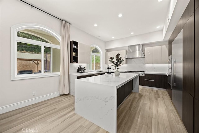 1279 Waterbrook Cir, Walnut, CA 91789 - kitchen with modern cabinets, wall chimney exhaust hood, a kitchen island, light wood-style floors, and stainless steel gas stovetop