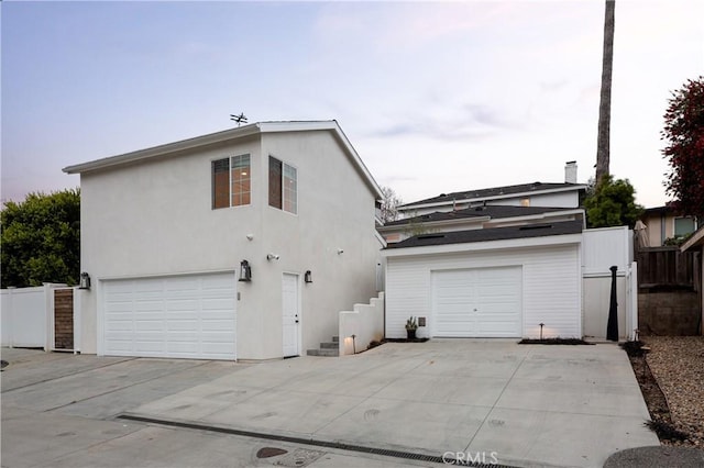 425 Tustin Ave, Newport Beach, CA 92663 - rear view of house featuring a garage, concrete driveway, and stucco siding