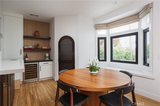 425 Tustin Ave, Newport Beach, CA 92663 - dining space with wine cooler, light wood-style flooring, and a bar