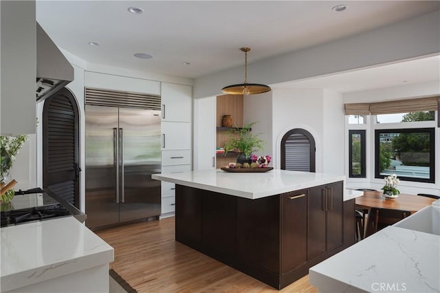425 Tustin Ave, Newport Beach, CA 92663 - kitchen featuring built in refrigerator, modern cabinets, hanging light fixtures, light wood-style floors, and white cabinetry