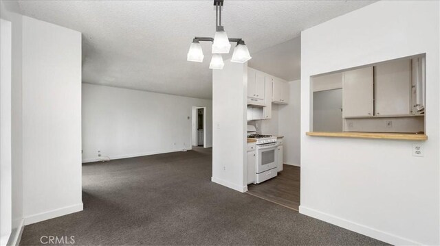 3649 Glendon Ave Unit 202, Los Angeles, CA 90034 - kitchen featuring white gas range oven, dark colored carpet, baseboards, light countertops, and a textured ceiling