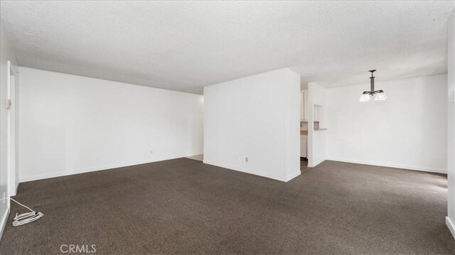 3649 Glendon Ave Unit 202, Los Angeles, CA 90034 - unfurnished living room with dark carpet, a textured ceiling, baseboards, and a chandelier